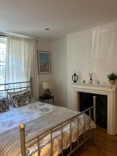 伦敦2bed house in Vauxhall的一间卧室配有一张床和一个壁炉