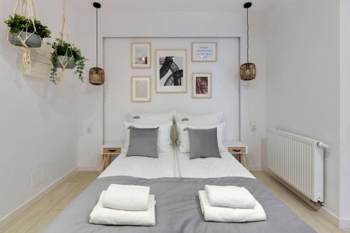 格但斯克Downtown Apartments Riverside Aura Island的白色卧室配有一张带两个枕头的大床