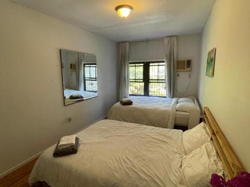 布鲁克林Spacious Bedroom for 4 in shared Townhouse+garden的小房间设有两张床和镜子