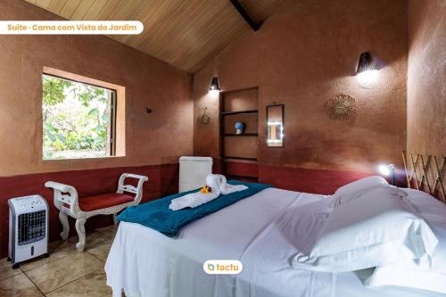 瓜拉米兰加Pousada Le Monte Cristo c/ Café Guaramiranga的一间卧室配有一张床和一张红色椅子