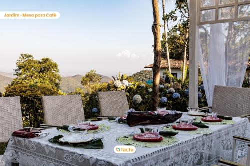 瓜拉米兰加Pousada Le Monte Cristo c/ Café Guaramiranga的桌子上配有白色桌布和椅子