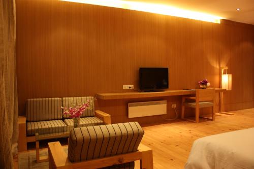 帕罗Udumwara Resort的酒店客房配有一张床和一张书桌及一台电视