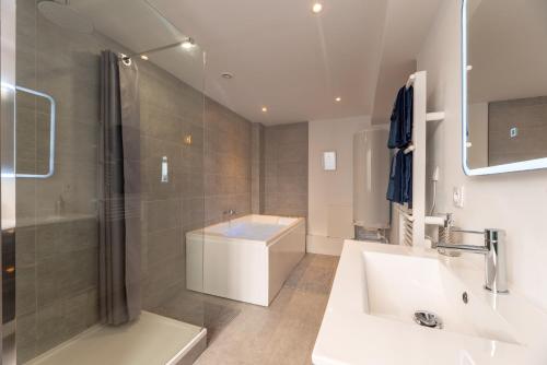 鲁昂Le Lovely cosy jacuzzi centre-ville wifi的浴室配有水槽、淋浴和浴缸。