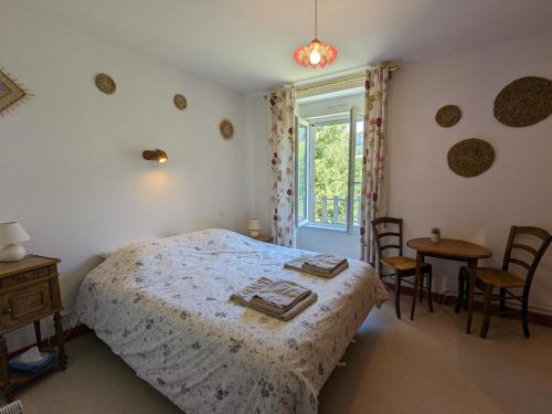 Le ClauxL'Estive du Claux的一间卧室配有一张床、一张桌子和一个窗户。