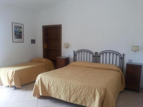 波利卡Agriturismo La Mancosa的一间卧室配有两张床和橱柜