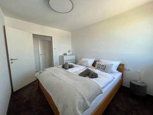 沃尔富特Sonnige Wohnung mit schöner Aussicht in Wolfurt的卧室配有一张带白色床单和枕头的大床。