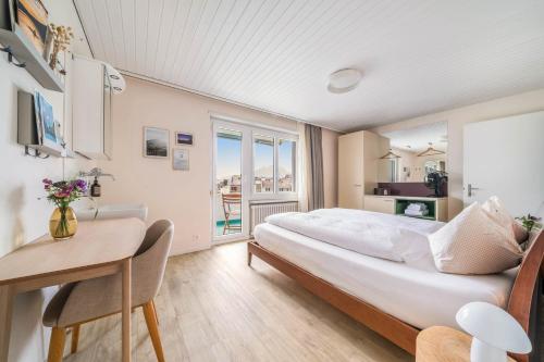 韦吉斯万得拉斯特旅馆的一间带一张大床和一张书桌的卧室以及一个阳台