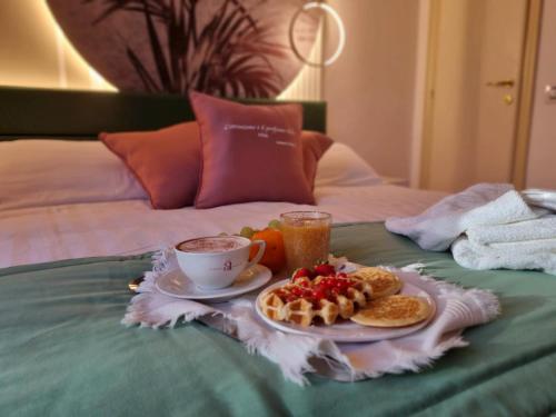 里米尼安格里尼酒店的早餐盘,包括早餐食品和床上的咖啡