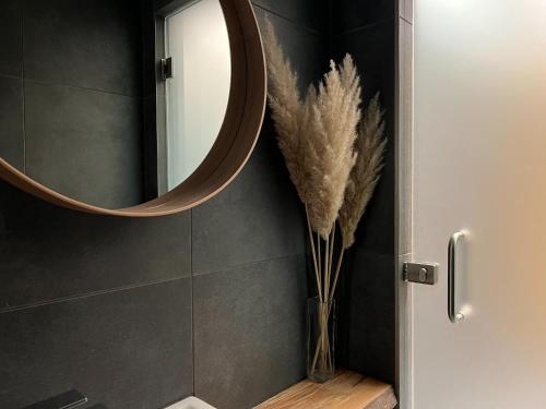 Matrakeresztes马特雷克斯泰斯弾博罗姆沃尔基度假酒店的浴室设有镜子和带羽毛的花瓶