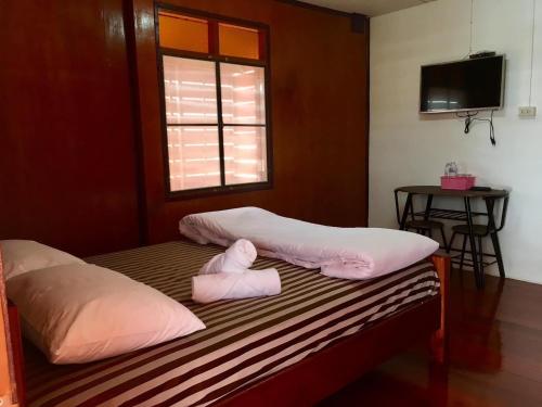 清刊Baan Fun Dee Chiang Khan的客房设有两张带粉红色枕头的床和窗户。