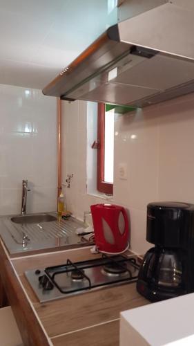 卡尔维Clos SAN MICHELE- LE PAILLER的厨房配有炉灶和红色椅子