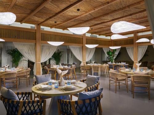 乌姆赛义德Ramlah Resort Qatar的餐厅设有木制天花板和桌椅