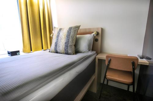哥德堡Comfort Hotel City的一间卧室配有一张带椅子的床和一扇窗户