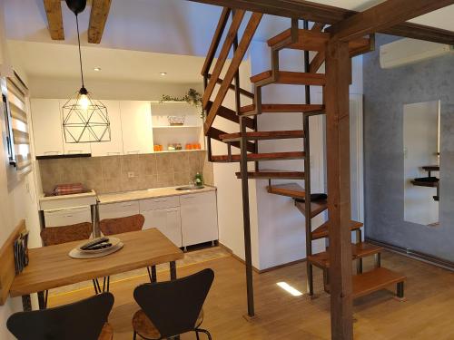 维尔蒂尼克Garden 022的一间厨房和带木制螺旋楼梯的用餐室