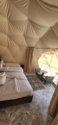 瓦迪拉姆Family Camp的一间卧室配有两张床,帐篷内配有一张桌子