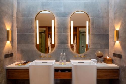 沙努尔Sumitra Luxury Villas A Pramana Experience的浴室设有2个水槽和2个镜子
