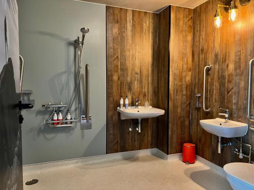 卡斯尔顿Bike & Boot Inns Peak District - Leisure Hotels for Now的一间带两个水槽和木墙的浴室