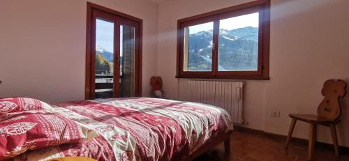 博尔米奥Appartamento con splendida vista su pista Stelvio的一间卧室设有一张床和一个享有山景的窗户。