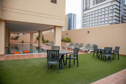 朱菲尔Juffair Trends Luxury Apartment的一个带桌椅的庭院和一个游泳池