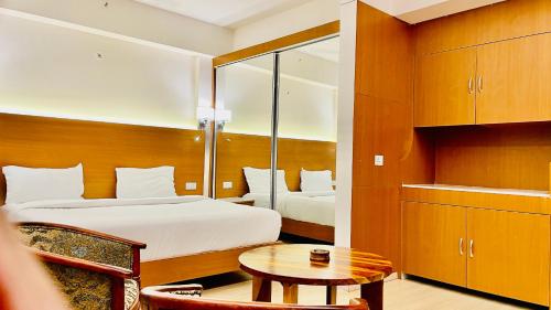 勒克瑙Neel Skye - Couple Friendly - DLF My Pad, Gomtinagar , Lucknow的酒店客房配有一张床铺和一张桌子。