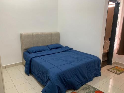 巴力文打HOMESTAY HONEY PARIT BUNTAR的一间卧室配有一张带蓝色棉被的床