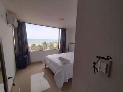 里奥阿查RH03 Riohacha apartamento perfecto para trabajar o vacacionar frente a la playa的一间卧室设有一张床和一个大窗户