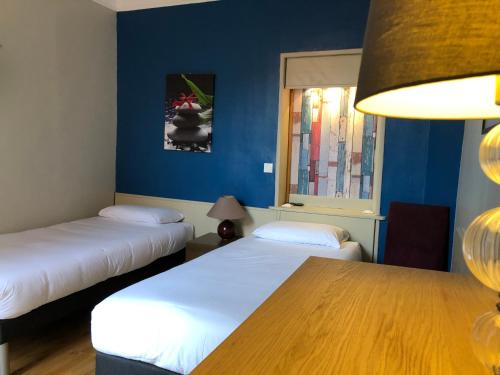 维勒瑞夫自由别墅酒店的配有两张床铺的蓝色墙壁和一张桌子