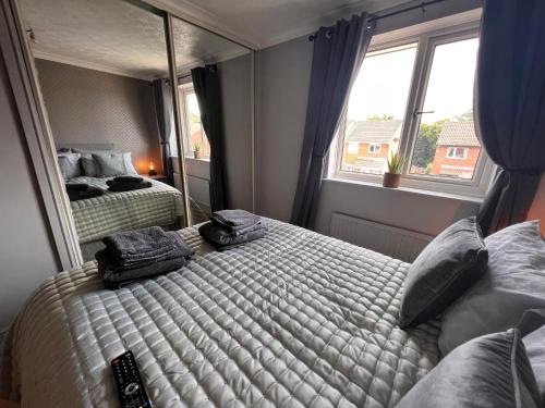 CONTRACTORS OR FAMILY HOUSE - M1 Nottingham - IKEA RETAIL PARK - CATKIN DRIVE - 2 Bed Home with Driveway, private garden, sleeps 4 - TV'S in all rooms的一间卧室设有两张床和大镜子