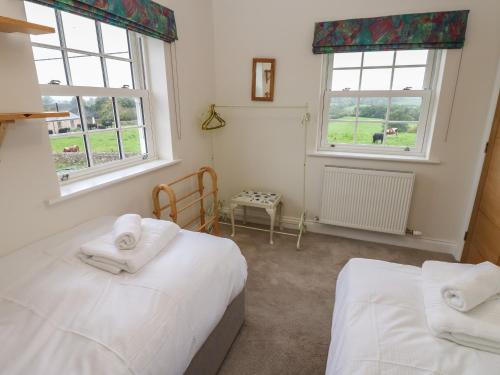 彭里斯Larch House的一间卧室设有两张床和两个窗户。