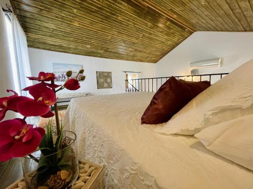 CorredouraTufa Guest House, Wellness & SPA - Villa Campus的一间卧室配有床和花瓶