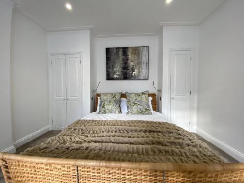 伦敦Stylish Traveller's Heaven的一间卧室配有一张大床和柳条床头板