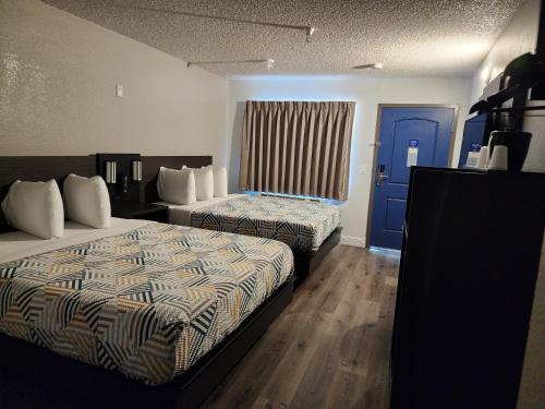 萨克拉门托Motel 6 Sacramento CA Natomas的酒店客房带两张床和一扇蓝色门
