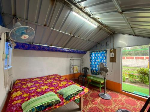 巴卡哈利Tapama Resort的卧室配有1张床、风扇和窗户。