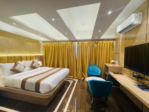 孟买Home2 Renaissance Club的酒店客房设有床、书桌和显示器。
