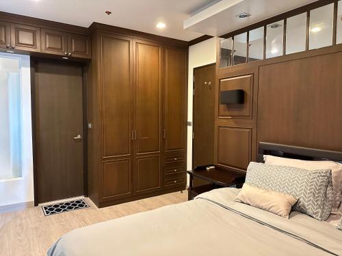 曼谷OV Residence的一间卧室配有一张床和木制橱柜