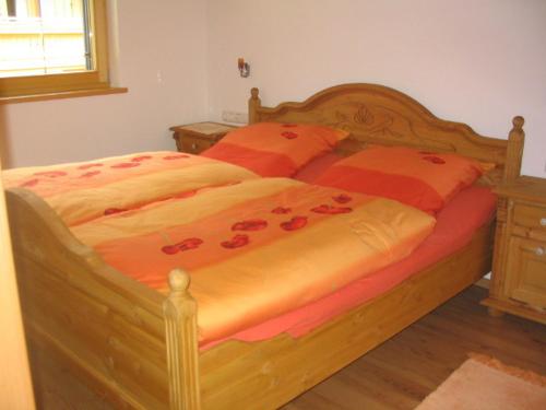 SachrangFerienhaus Sachrang的一间卧室,床上有红色的鲜花