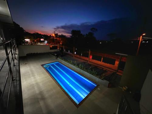 莱蒂西亚Apartamentos Sin fronteras的游泳池,晚上在阳台上拥有蓝色的灯光