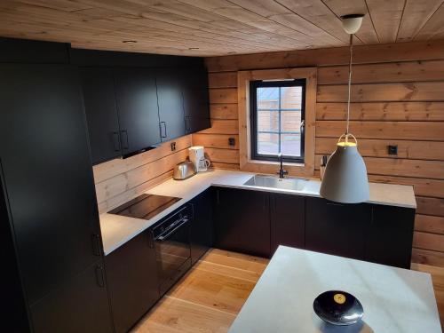 伊德勒Idre Mountain Lodge Golfbanan的厨房配有黑色橱柜、水槽和窗户。