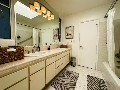 洛杉矶Urban Oasis: Stylish Mid-Century Home in Weho的一间带两个盥洗盆和大镜子的浴室