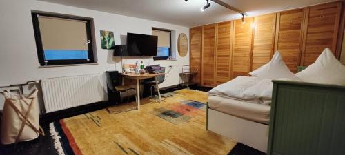 科隆Spacious & comfortable guestrooms w private bathrooms near Koelnmesse & Lanxess Arena, free parking, highspeed WiFi的一间卧室配有一张床和一张书桌及电视