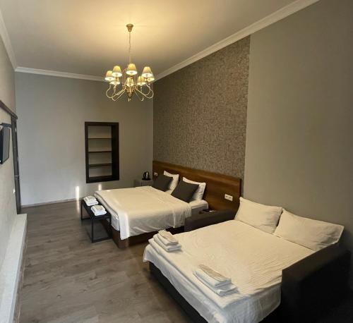 第比利斯2nd Floor Hotel的酒店客房设有两张床和吊灯。