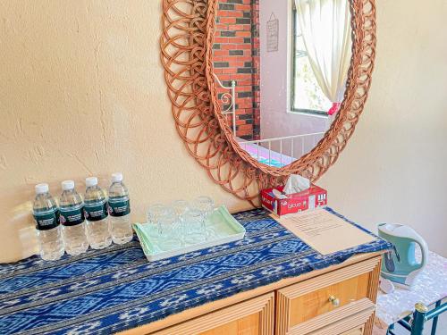 峇六拜Dusun Indah Cottage 2的配有瓶装水和镜子的柜台