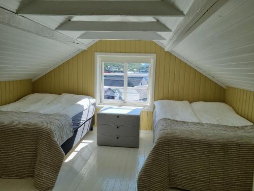 SkjervøyLoftsleilighet midt i sentrum的带窗户的客房内的两张床
