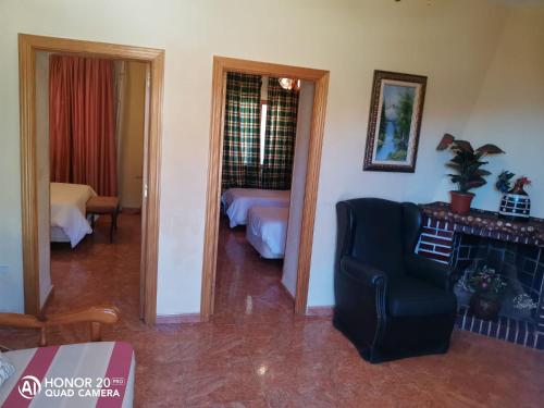 瓜达拉马Hotel Sierra Oriente的客厅设有一张床和一把椅子