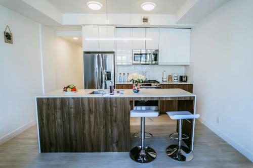 卡尔加里Vibrant & Modern Loft-style Walkout Near LRT的厨房配有木台面和凳子