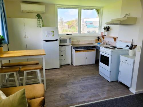 沃纳姆堡高地景家庭小屋的铺有木地板的厨房配有白色家电