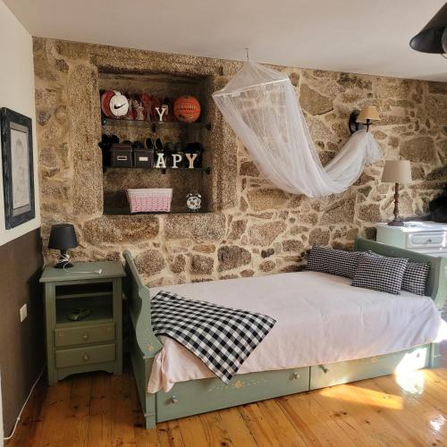 里瓦达维亚El Abuelo Angel的一间卧室设有一张床和石墙