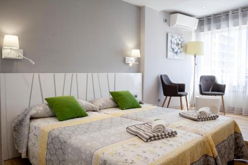 莱昂BURGO NUEVO Ático de lujo en pleno centro con terraza y vistas - leonapartamentos的一间卧室配有一张大床和两个绿色枕头