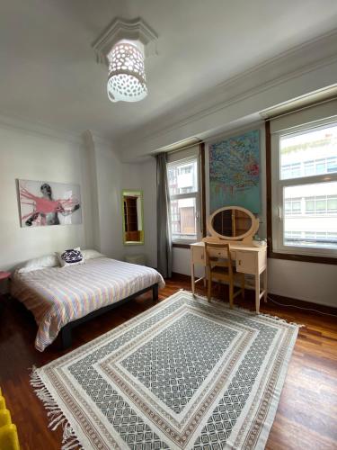 拉科鲁尼亚Habitación Céntrica的一间卧室配有一张床、一张桌子和一张地毯。