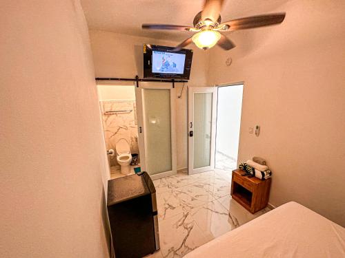 圣胡安OMERO Ocean Park的卧室配有吊扇和墙上的电视。